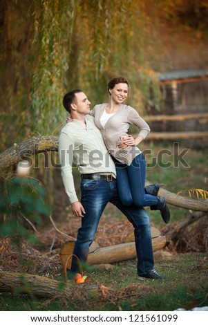 playful young couple in love having fun enjoy a moment of happiness on nature. handsome guy and beautiful brunette woman enjoying spring holiday together. Loving couple on date in park looking happy