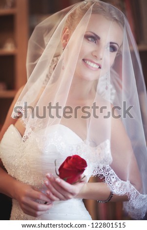 Wedding: Happy beautiful bride blond girl in white wedding dress with hairstyle and bright makeup waiting for groom. Romantic woman in bridal dress have final preparation for wedding and smiling