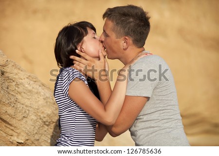 Loving playful couple on sand beach at honeymoon travel hugging and kissing in summer. Happy smiling family together in moment of happiness. man and woman on date on tropical island on Valentines day