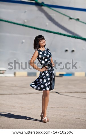 Beautiful Vacation Woman in dock at big cruise ship happy summer woman smiling at sea trip. Happy travel woman sexy girl in summer dress. Sea vacation girl. Resting woman at cruise liner. tourist girl