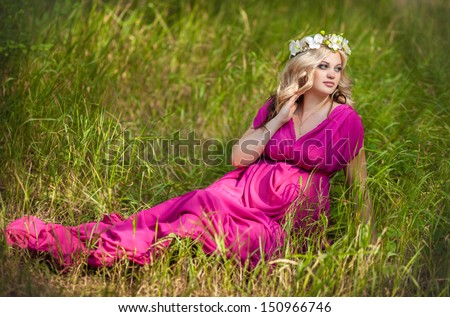 Happy pregnant woman on nature relaxing, pregnancy girl. Beautiful pregnant girl outdoors. Happy pregnancy. Attractive pregnant woman in park. Pregnant woman romantic fairy style. Woman with flowers