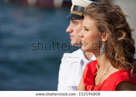 Happy Couple in love on dating Man and woman embracing and watching sea sunset. military seaman and his girlfriend near sea. Man and woman talking and hugging. Happy dating. Boyfriend and girlfriend.