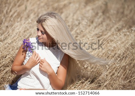 beautiful young Caucasian woman outdoor, healthy sensual girl at wheat field. Happy  blonde woman resting. Natural makeup hairstyle. long hair perfect skin. young woman outdoors. Natural blond hair