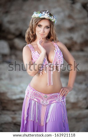 Beautiful sexy woman bellydancer in purple dress outdoors. Professional arabian dancer portrait. exotic star of bellydance.