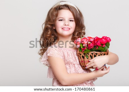 Cute child girl with spring flowers, portrait of little girl with basket of flowers isolated on white background.