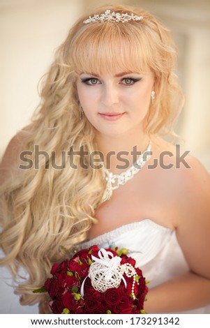 Beautiful Bride Wedding Portrait Outdoors, newlywed woman in wedding dress with bridal flowers. Happy Bride posing in on nature.