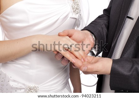 Hands with rings Groom putting golden ring on bride\'s finger during wedding ceremony Loving couple closeup in studio isolated portrait on white background
