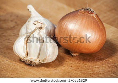 Bulbs of onion and garlic on wooden surface