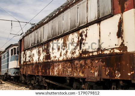 Abandoned rusty rail-cars with cracked peeling paint