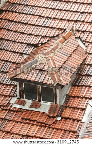 Part of the roof of old townhouse with wet from rain tiles