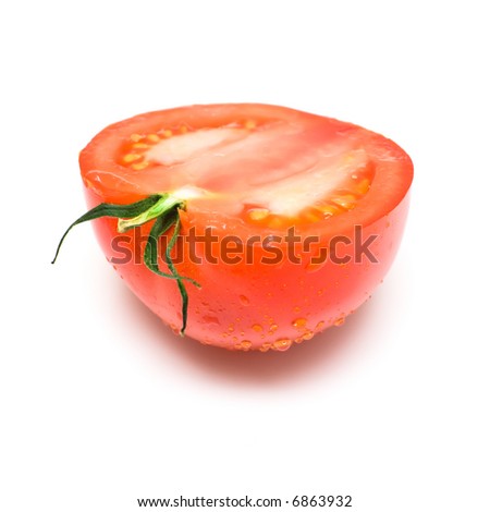 The ripe tomato covered by drops of water and cut half-and-half isolated on white. Shallow DOF.