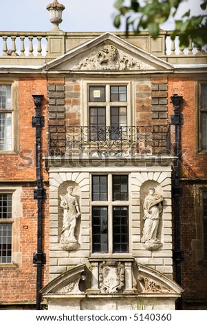 English mansion house showing statues above entrance, and balcony