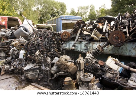 assorted old auto parts in a breakers yard