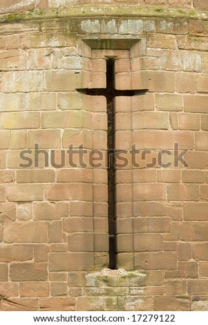 cross shaped window in ruins of castle