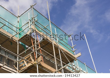 tall building scaffolding against a blue sky