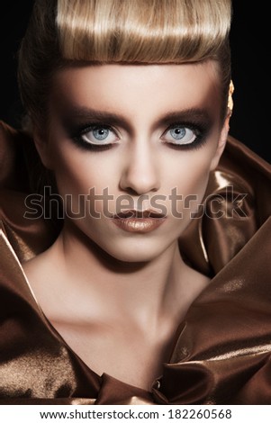 Fashion portrait of a girl in gold color