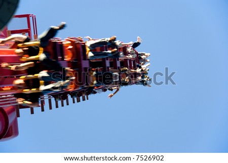Roller coaster with riders feet hanging over the edge