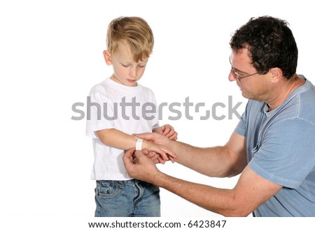 Handsome father putting a band aid on his son’s arm