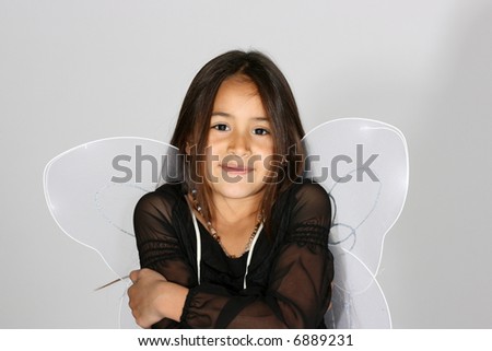 Portrait of cute young girl with rhinestone tiara and fairy wings