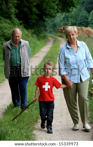 young boy taking a walk in nature with grandma and grandpa