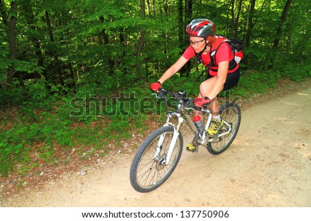 Woman riding a mountain bike on the forest trail