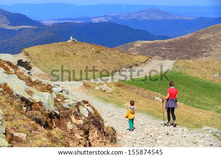 Boy and mother during family hike on mountain trail