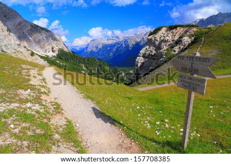 Mountain trail, green meadow and distant mountains, Dolomite Alps, Italy