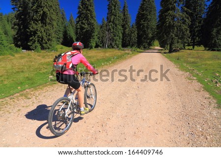 Young woman cycling on a mountain road during summer