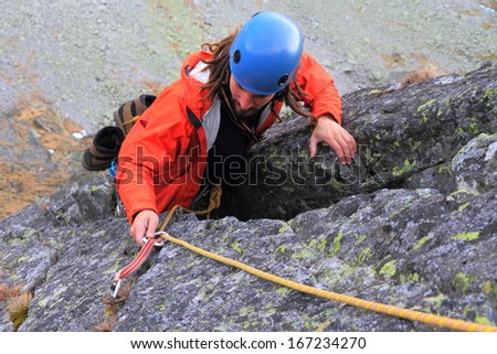 Climber removing protection gear from granite rock face