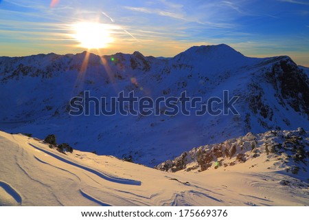Sun sets over the mountains and valleys in winter