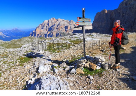 Direction indicator and tourist searching the route, Dolomite Alps, Italy