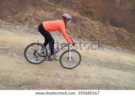 Fast descent of a woman riding a bike on dirt road