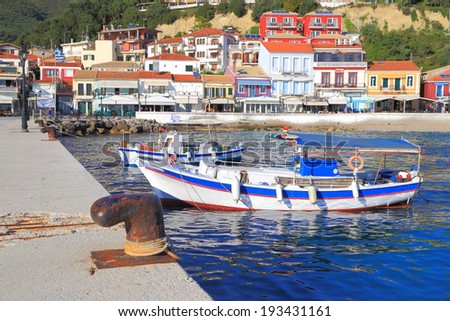 Fishing boats near stone pier on the shores of blue sea, Greece