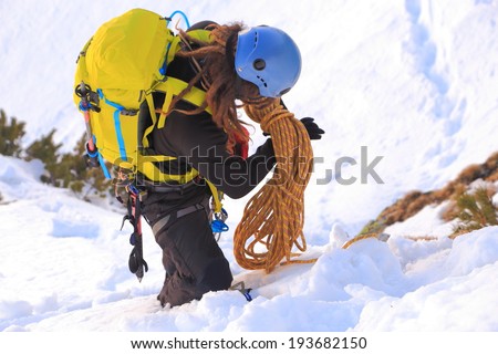 Mountaineer packs the climbing rope in winter