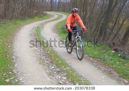 Woman cycling a forest road on a mountain bike