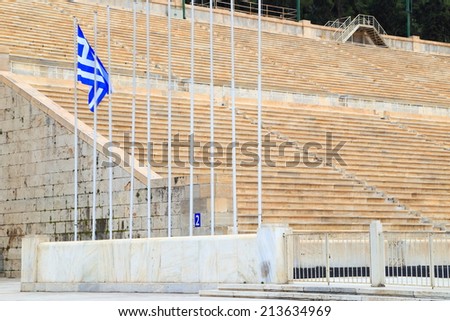 Greek flag and rows of seats on an ancient stadium in Athens, Greece