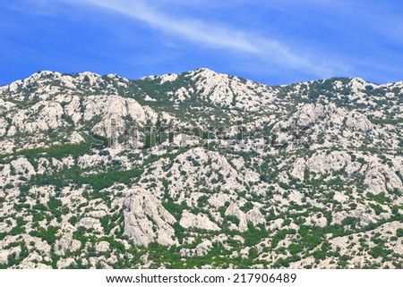 Limestone mountains spotted with green bushes on the Dalmatian coast, Croatia