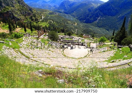Tourists visiting large amphitheater located on a beautiful valley at Delphi, Greece