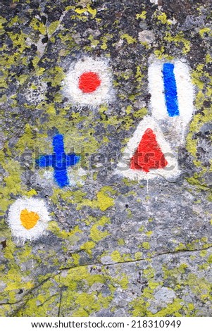 Mixture of trail signs painted on granite rock