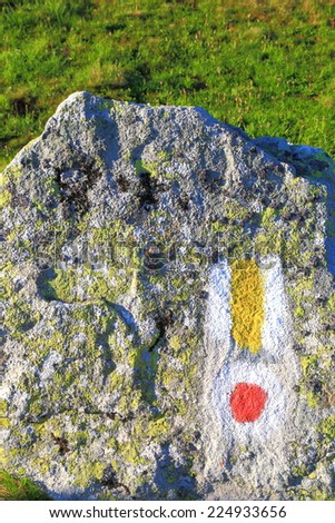 Colorful trail marks painted on granite boulder on the mountain