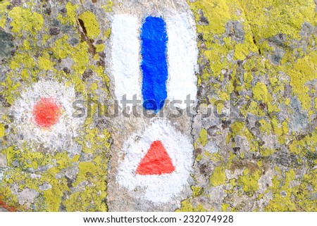 Colorful trail signs painted on green rock