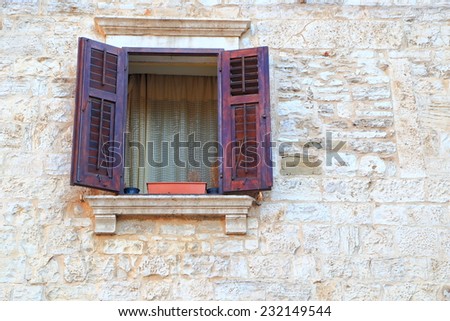 Vintage window with brown wood shutters on a street of Venetian town, Pula, Croatia