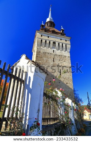 Tall medieval tower of fortified church from UNESCO world heritage list in Saschiz village, Transylvania, Romania