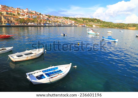 Small white boats scattered inside the harbor of Koroni, Greece