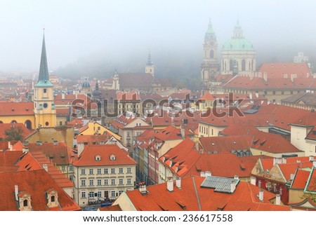 Church towers and dome amongst roof tops in foggy weather, Prague, Czech Republic