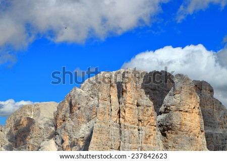 Sunny day on the mountains with para glider flying above steep summits, Catinaccio massif, Dolomite Alps, Italy