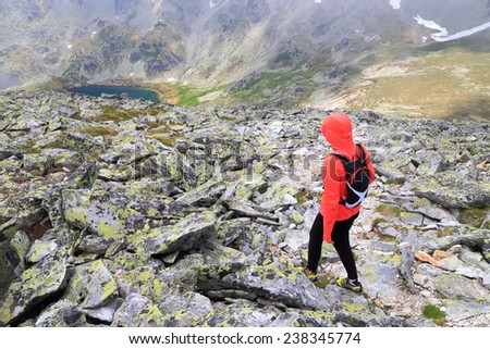 Woman hiking on large boulders descending to the valley