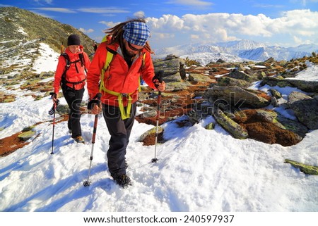 Mountain hikers on snow covered ridge in fine winter day
