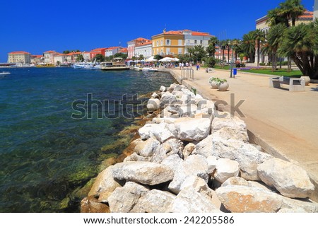 Seaside walkway protected by large boulders on the shores of Adriatic sea resort, Porec, Croatia