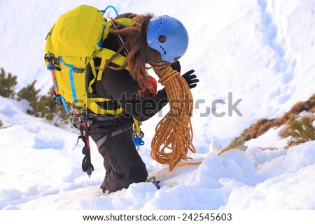 Mountaineer packs the rope after climbing in winter